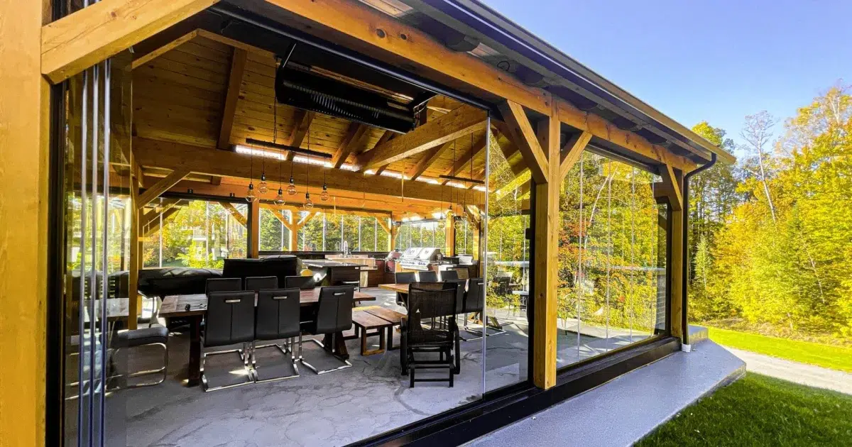 Pivoting glass panels stack at the side to open the sheltered patio to the yard.