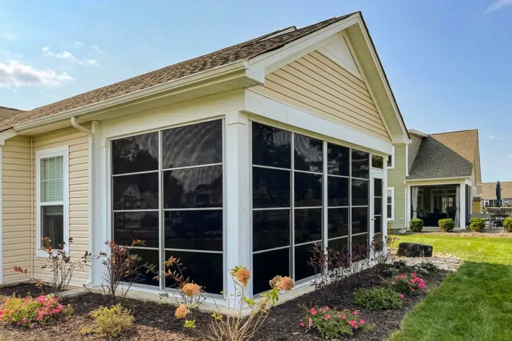White sunroom addition with dark-tinted four-track vinyl windows