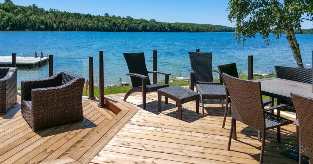 Topless glass railing preserving an open lake view from a furnished deck