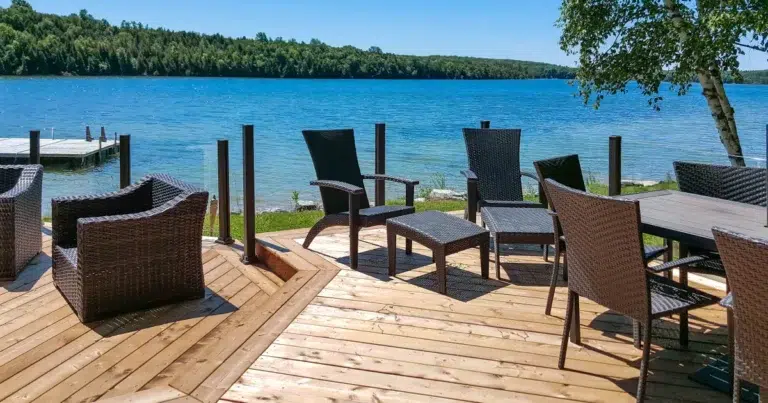 Topless glass railing preserving an open lake view from a furnished deck